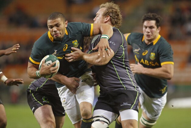 South Africa Springboks Bryan Habana, left, tries to run with the ball as World XV's Pat Cilliers, right, try to stop him during their game in Cape Town, South Africa, Saturday, June 7, 2014.  (AP Photo/Schalk van Zuydam)