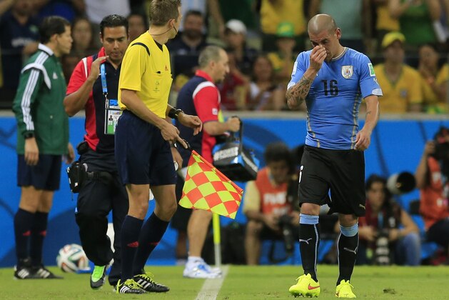 Uruguay's Maxi Pereira leaves the pitch after getting a red card during the group D World Cup soccer match between Uruguay and Costa Rica at the Arena Castelao in Fortaleza, Brazil, Saturday, June 14, 2014.(AP Photo/Bernat Armangue)