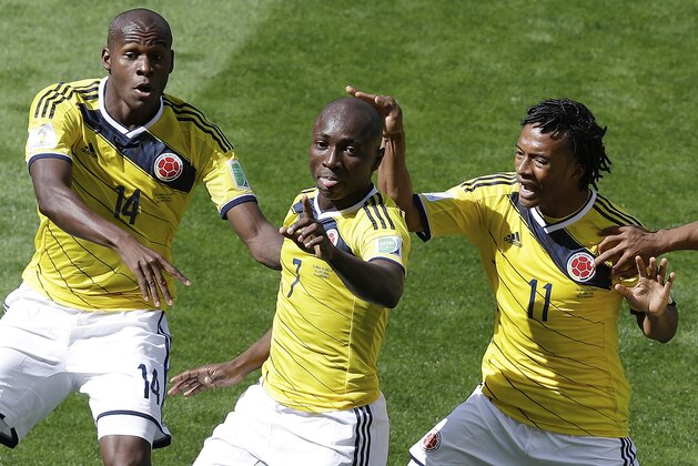 Colombia's Pablo Armero, center, celebrates with teammates, Victor Ibarbo, left, and Juan Cuadrado, right, after scoring during the group C World Cup soccer match between Colombia and Greece at the Mineirao Stadium in Belo Horizonte, Brazil, Saturday, June 14, 2014.  (AP Photo/Andrew Medichini)