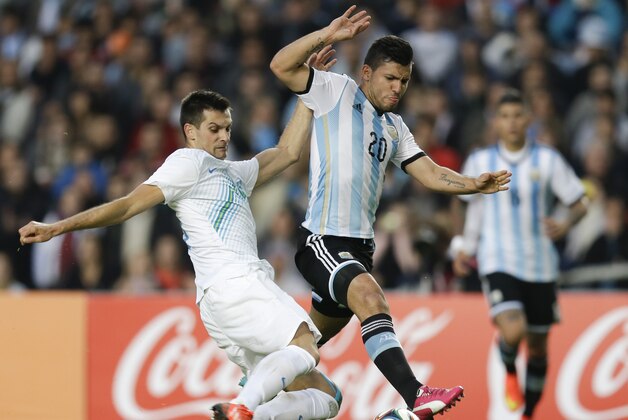 Argentina's Sergio Aguero, right, fights for the ball with Slovenia's Miral Samardzic during their international friendly soccer match in La Plata, Argentina, Saturday, June 7, 2014. Argentina's team is leaving June 9 for Brazil to compete in the World Cup. (AP Photo/Natacha Pisarenko)