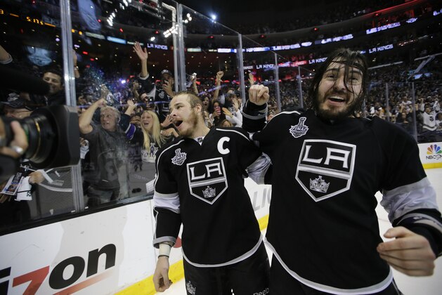 Los Angeles Kings right wing Dustin Brown, left, and teammate defenseman Drew Doughty celebrate after beating the New York Rangers in overtime in Game 5 of the NHL Stanley Cup Final series Friday, June 13, 2014, in Los Angeles. (AP Photo/Jae C. Hong)