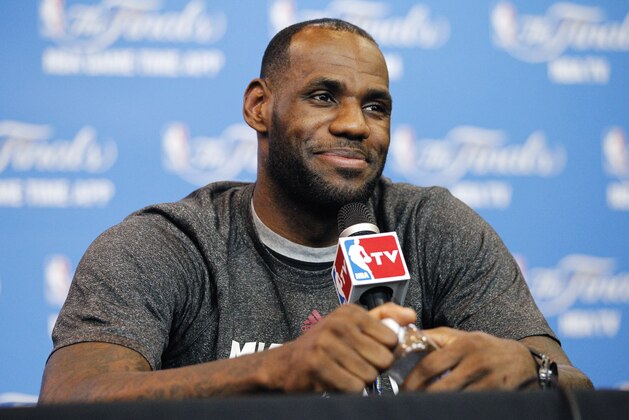 Miami Heat forward LeBron James smiles as he responds to a question during a media availability for the NBA basketball finals on Saturday, June 14, 2014, in San Antonio. Miami plays Game 5 against the San Antonio Spurs on Sunday. (AP Photo/Tony Gutierrez)