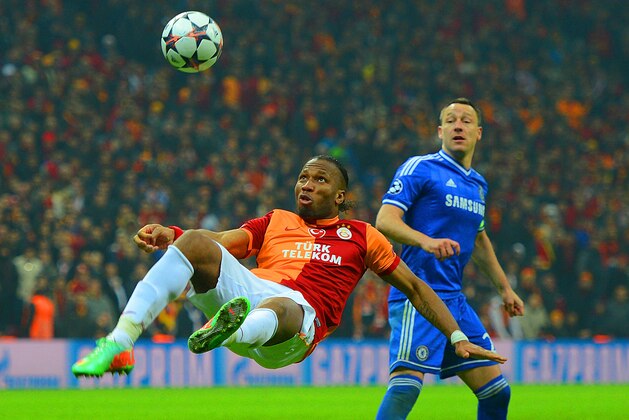 ISTANBUL, TURKEY - FEBRUARY 26:  John Terry of Chelsea looks on as Didier Drogba of Galatasaray clears the ball during the UEFA Champions League Round of 16 first leg match between Galatasaray AS and Chelsea at Ali Sami Yen Arena on February 26, 2014 in Istanbul, Turkey.  (Photo by Michael Regan/Getty Images)