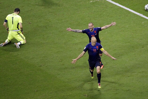 Spain's goalkeeper Iker Casillas rests on his knees in dejection as Netherlands' Arjen Robben celebrates after scoring followed by Netherlands' Wesley Sneijder during the group B World Cup soccer match between Spain and the Netherlands at the Arena Ponte Nova in Salvador, Brazil, Friday, June 13, 2014.  (AP Photo/Christophe Ena)