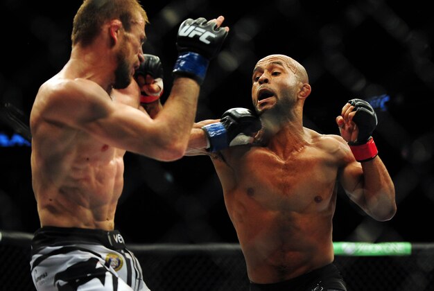 Jun 14, 2014; Vancouver, British Columbia, Canada; Demetrious Johnson (red) fights against Ali Bagautinov (blue) in the flyweight title bout at UFC 174 at Rogers Arena. Mandatory Credit: Anne-Marie Sorvin-USA TODAY Sports