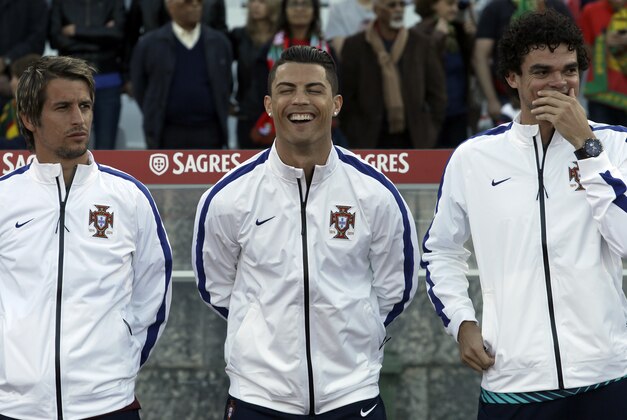 Portugal's Cristiano Ronaldo, centre, laughs with teammates Fabio Coentrao, left, and Pepe prior a friendly soccer match between Portugal and Greece at the National stadium, in Oeiras, near Lisbon, Saturday, May 31, 2014. The game was a warm-up match for both teams ahead the World Cup in Brazil. The match ended in a 0-0 draw. (AP Photo/Francisco Seco)