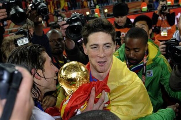 Spain's Fernando Torres, center, and Sergio Ramos, left, hold the World Cup trophy after the World Cup final soccer match between the Netherlands and Spain at Soccer City in Johannesburg, South Africa, Sunday, July 11, 2010. Spain won 1-0.  (AP Photo/Martin Meissner)
