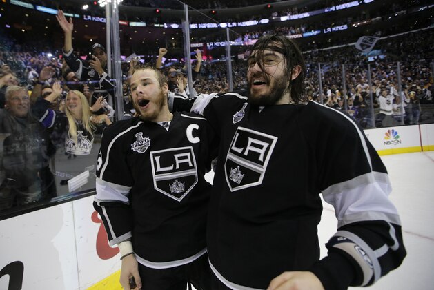 Los Angeles Kings right wing Dustin Brown, left, and teammate defenseman Drew Doughty celebrate after beating the New York Rangers in overtime in Game 5 of the NHL Stanley Cup Final series Friday, June 13, 2014, in Los Angeles. (AP Photo/Jae C. Hong)