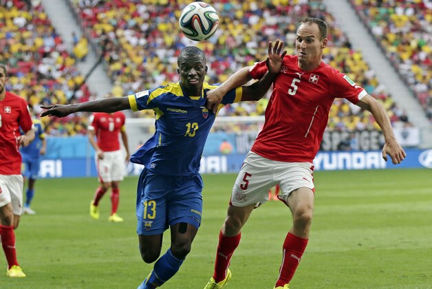 Ecuador's Enner Valencia pushes off Switzerland's Steve von Bergen as they try to reach the ball during the group E World Cup soccer match between Switzerland and Ecuador at the Estadio Nacional in Brasilia, Brazil, Sunday, June 15, 2014.  (AP Photo/Marcio Jose Sanchez)