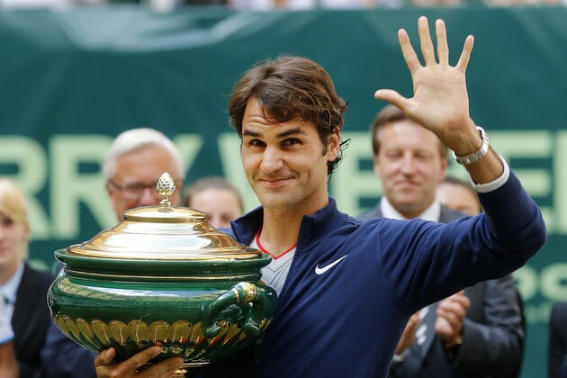 Switzerland's Roger Federer holds the trophy and waves after winning the final of the Gerry Weber Open tennis tournament in Halle, Germany, Sunday, June 15, 2014. Federer beat Colombia's Alejandro Falla 7-6 and 7-6. (AP Photo/Michael Probst)