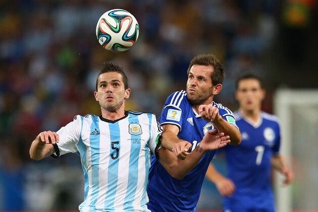 RIO DE JANEIRO, BRAZIL - JUNE 15: Fernando Gago of Argentina is challenged by Senad Lulic of Bosnia and Herzegovina during the 2014 FIFA World Cup Brazil Group F match between Argentina and Bosnia-Herzegovina at Maracana on June 15, 2014 in Rio de Janeiro, Brazil.  (Photo by Julian Finney/Getty Images)