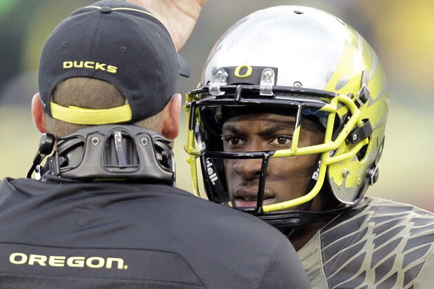 Oregon defender Ifo Ekpre-Olomu, right, is shown with head coach Mark Helfrich during the second half of an NCAA college football game against Utah in Eugene, Ore., Saturday, Nov. 16, 2013.  Oregon won 44-21. (AP Photo/Don Ryan)