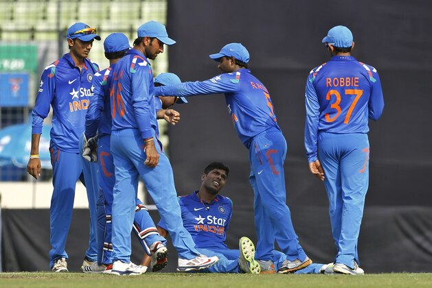 India's Umesh Yadav, sitting on ground, celebrates with his teammates the wicket of Bangladesh’s Ziaur Rahman during their first one-day International cricket match in Dhaka, Bangladesh, Sunday, June 15, 2014. (AP Photo/A.M. Ahad)