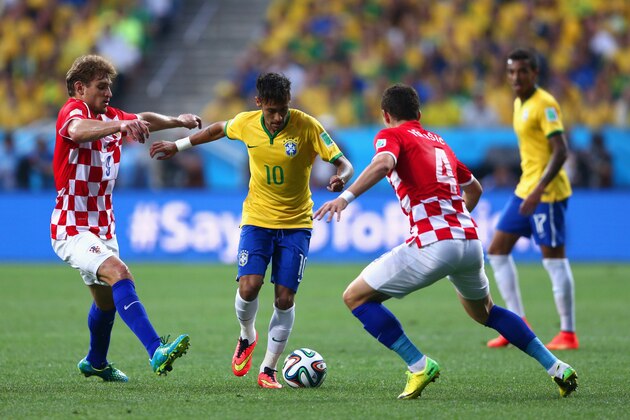 SAO PAULO, BRAZIL - JUNE 12: Neymar of Brazil controls the ball against Nikica Jelavic (L) and Ivan Perisic of Croatia (R) during the 2014 FIFA World Cup Brazil Group A match between Brazil and Croatia at Arena de Sao Paulo on June 12, 2014 in Sao Paulo, Brazil.  (Photo by Warren Little/Getty Images)