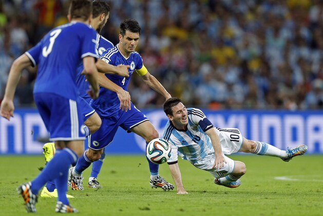 Argentina's Lionel Messi falls to the pitch after being fouled during the group F World Cup soccer match between Argentina and Bosnia at the Maracana Stadium in Rio de Janeiro, Brazil, Sunday, June 15, 2014.    (AP Photo/Victor R. Caivano)