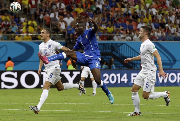 Italy's Mario Balotelli, centre, gets in-between England's Gary Cahill and England's Phil Jagielka, left, during the group D World Cup soccer match between England and Italy at the Arena da Amazonia in Manaus, Brazil, Saturday, June 14, 2014.  (AP Photo/Matt Dunham)