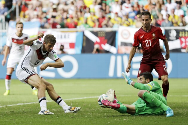 Germany's Thomas Mueller (13) kicks the ball at Portugal's goalkeeper Rui Patricio to score his side's fourth goal as Portugal's Joao Pereira (21) watches during the group G World Cup soccer match between Germany and Portugal at the Arena Fonte Nova in Salvador, Brazil, Monday, June 16, 2014. (AP Photo/Natacha Pisarenko)