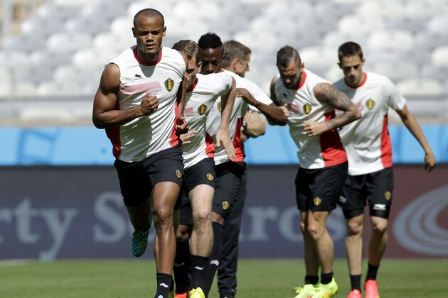 Belgium’s Vincent Kompany, left front, runs with teammates during a training session at the Mineirao Stadium in Belo Horizonte, Brazil, Monday, June 16, 2014.  Belgium will play in group H of the Brazil 2014 soccer World Cup.  (AP Photo/Bruno Magalhaes)
