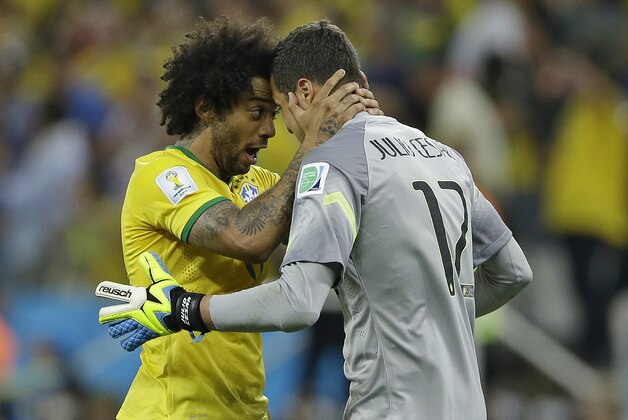 Brazil's goalkeeper Julio Cesar celebrates with Marcelo after Oscar scored the 3rd goal during the group A World Cup soccer match between Brazil and Croatia, the opening game of the tournament, in the Itaquerao Stadium in Sao Paulo, Brazil, Thursday, June 12, 2014. (AP Photo/Kirsty Wigglesworth)