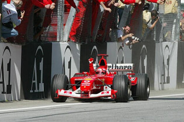Germany's Michael Schumacher of Team Ferrari clinches the fist after crossing the finish line in first position celebrated by his team during the Austrian Formula One Grand Prix in Spielberg, Austria, on Sunday, May 18, 2003. Schumacher won ahead of Finnland's Kimi Raikonen and Brazil's Rubens Barrichello.  (AP Photo/Daniel Maurer)