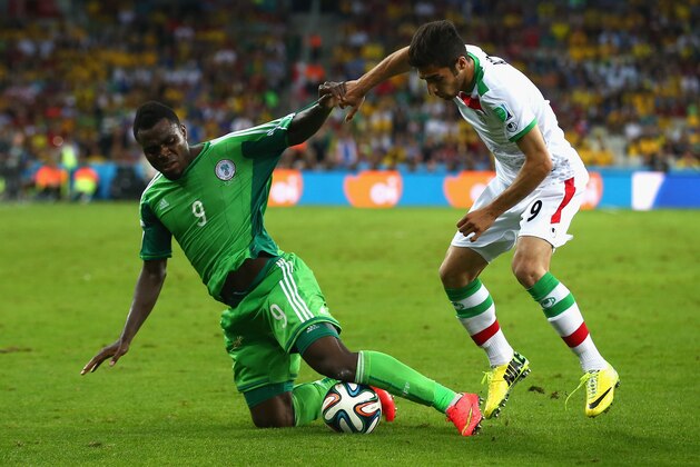 CURITIBA, BRAZIL - JUNE 16:  Emmanuel Emenike of Nigeria and Alireza Jahan Bakhsh of Iran battle for the ball during the 2014 FIFA World Cup Brazil Group F match between Iran and Nigeria at Arena da Baixada on June 16, 2014 in Curitiba, Brazil.  (Photo by Julian Finney/Getty Images)