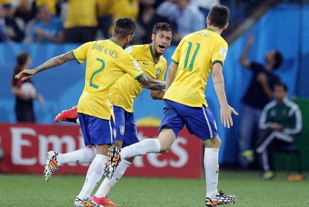 Brazil's Neymar celebrates with teammates Oscar, right, and Dani Alves, left, after scoring during their group A World Cup soccer match against Croatia in the opening game of the tournament at Itaquerao Stadium in Sao Paulo, Brazil, Thursday, June 12, 2014. (AP Photo/Frank Augstein)