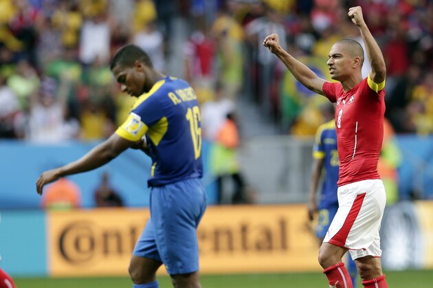 Switzerland's Goekhan Inler, right, celebrates his team's 2-1 victory over Ecuador during the group E World Cup soccer match between Switzerland and Ecuador at the Estadio Nacional in Brasilia, Brazil, Sunday, June 15, 2014.  (AP Photo/Marcio Jose Sanchez)