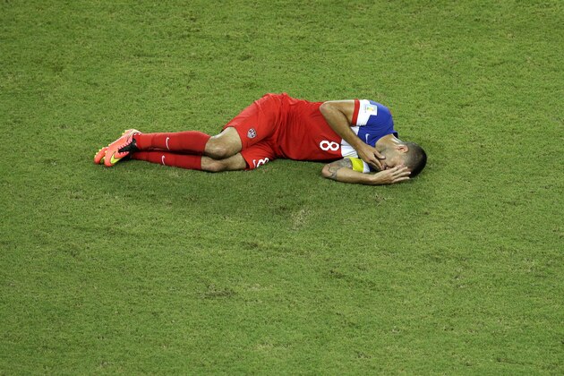 United States' Clint Dempsey lies on the pitch after being kicked in the face during the group G World Cup soccer match between Ghana and the United States at the Arena das Dunas in Natal, Brazil, Monday, June 16, 2014. (AP Photo/Hassan Ammar)