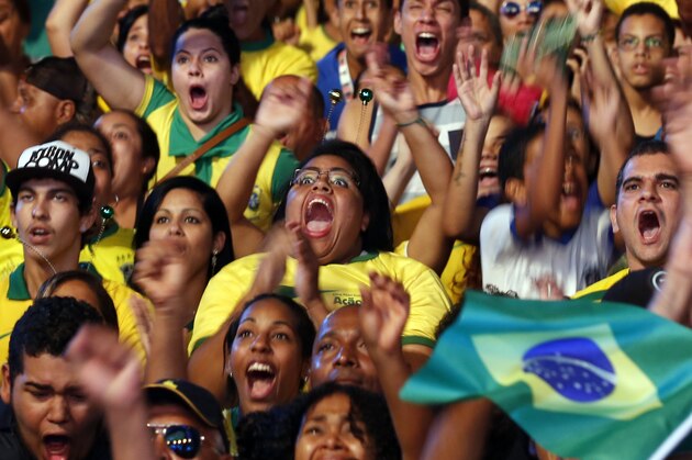 In this Thursday, June 12, 2014 photo, Brazilians celebrate after their team scores a goal against Croatia in the 2014 soccer World Cup opening game at a Fan Fest complex in Recife, Brazil. With Brazil struggling and down a goal against a spirited Croatian team, Neymar came through to lead his team to a 3-1 win in the opening match, scoring once in each half. (AP Photo/Dolores Ochoa)