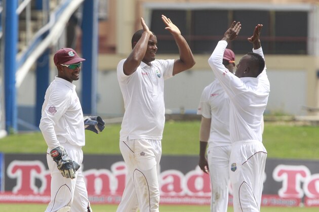 West Indies fast bowler Shannon Gabriel, center, high fives with teammate Jermaine Blackwood, right, as the wicket keeper and captain Denesh Ramdin, left, look on after taking the wicket of New Zealand's Kane Williamson, who was caught by Jason Holder for 42 runs, during the opening day of the second cricket Test match in Port of Spain, Trinidad, Monday, June 16, 2014. (AP Photo/Arnulfo Franco)
