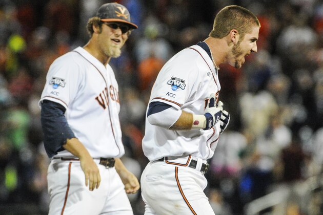 Virginia's Mike Papi, right, and teammate Austin Young, celebrate after Papi hit a double in the ninth inning against Missisippi that scored Thomas Woodruff to win an NCAA baseball College World Series game in Omaha, Neb., Sunday, June 15, 2014. Virginia won 2-1. (AP Photo/Eric Francis)