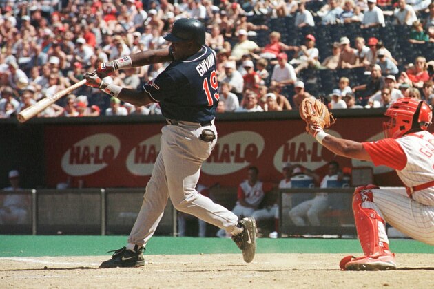 San Diego Padres' Tony Gwynn hits a sacrifice fly to center field for the go-ahead run in the eighth inning against the Cincinnati Reds, Sunday, July 19, 1998, in Cincinnati. The Padres won 7-6.  Reds catcher Guillermo Garcia is at right. (AP Photo/Tony Guttierez)