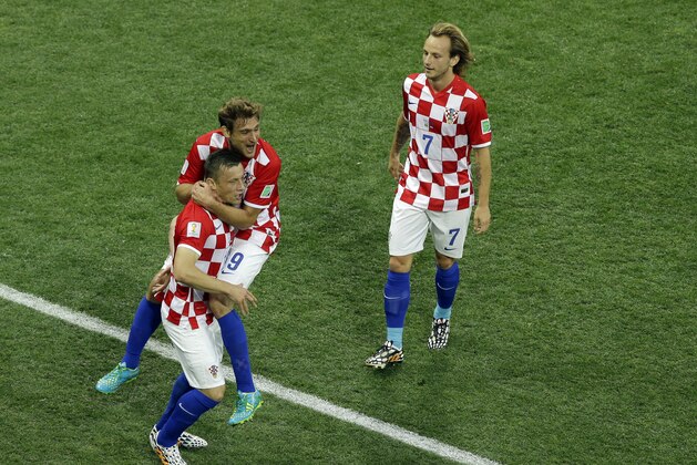 Croatia's Ivica Olic, celebrates with his teammates Nikica Jelavic and Ivan Rakitic, from left, after Brazil's Marcelo scored an own goal during the group A World Cup soccer match between Brazil and Croatia, the opening game of the tournament, in the Itaquerao Stadium in Sao Paulo, Brazil, Thursday, June 12, 2014. (AP Photo/Thanassis Stavrakis)