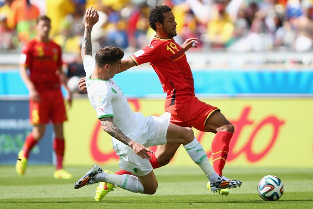 BELO HORIZONTE, BRAZIL - JUNE 17:  Carl Medjani of Algeria tackles Moussa Dembele of Belgium during the 2014 FIFA World Cup Brazil Group H match between Belgium and Algeria at Estadio Mineirao on June 17, 2014 in Belo Horizonte, Brazil.  (Photo by Ian Walton/Getty Images)