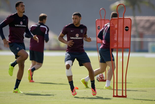 England national soccer team player Alex Oxlade-Chamberlain, center, who is recovering from a knee injury, takes part in a drill beside Chris Smalling, left, during a squad training session for the 2014 soccer World Cup at the Urca military base in Rio de Janeiro, Brazil, Monday, June 16, 2014.  (AP Photo/Matt Dunham)
