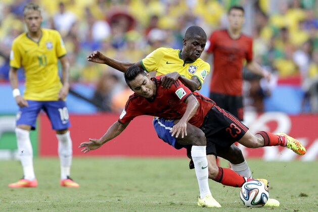 Mexico's Jose Juan Vazquez, front, is challenged by Brazil's Ramires during the group A World Cup soccer match between Brazil and Mexico at the Arena Castelao in Fortaleza, Brazil, Tuesday, June 17, 2014. (AP Photo/Andre Penner)
