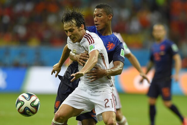 Netherlands' Jonathan de Guzman, right, grabs hold of Spain's David Silva during the group B World Cup soccer match between Spain and the Netherlands at the Arena Ponte Nova in Salvador, Brazil, Friday, June 13, 2014. (AP Photo/Manu Fernandez)