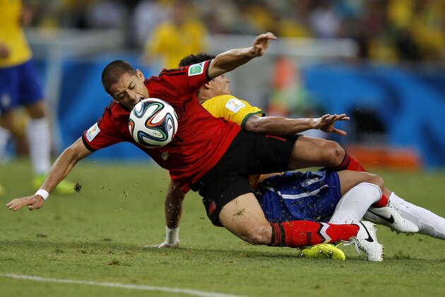 Mexico's Javier Hernandez, left, and Brazil's Thiago Silva collide as they fight for the ball during the group A World Cup soccer match between Brazil and Mexico at the Arena Castelao in Fortaleza, Brazil, Tuesday, June 17, 2014.  (AP Photo/Eduardo Verdugo)