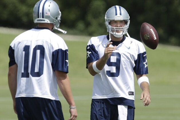 Dallas Cowboys quarterback Tony Romo (9)  takes a ball during an NFL football minicamp Tuesday, June 17, 2014, in Irving, Texas. (AP Photo/LM Otero)