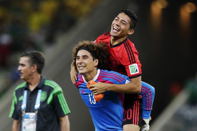 Mexico's goalkeeper Guillermo Ochoa (13) carries his teammate Mexico's Javier Aquino after their 0-0 tie with Brazil during the group A World Cup soccer match between Brazil and Mexico at the Arena Castelao in Fortaleza, Brazil, Tuesday, June 17, 2014. (AP Photo/Marcio Jose Sanchez)