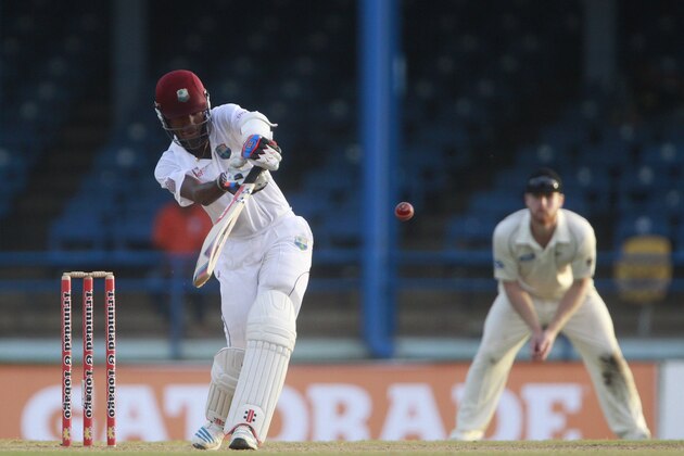West Indies opening batsman Kraigg Brathwaite, left, hits a shot that is caught by New Zealand bowler Trent Boult for 129 runs during the second day of their second cricket Test match in Port of Spain, Trinidad, Tuesday, June 17, 2014. (AP Photo/Arnulfo Franco)