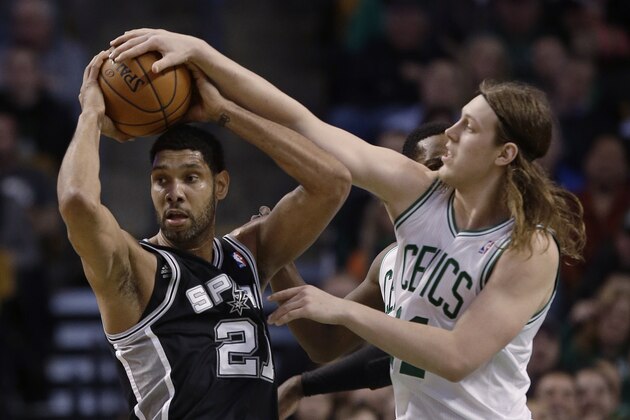 Boston Celtics center Kelly Olynyk, right, fouls San Antonio Spurs forward Tim Duncan (21) as Duncan comes down with the rebound during the second half of an NBA basketball game in Boston, Wednesday, Feb. 12, 2014. The Spurs defeated the Celtics 104-92. (AP Photo/Stephan Savoia)
