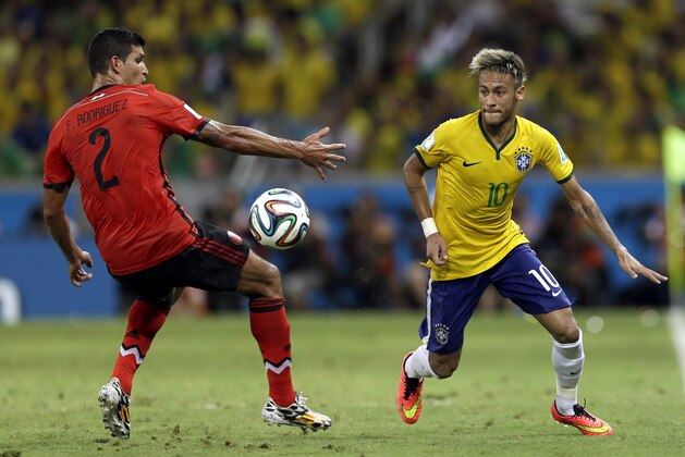 Brazil's Neymar, right, gets past Mexico's Francisco Rodriguez during the group A World Cup soccer match between Brazil and Mexico at the Arena Castelao in Fortaleza, Brazil, Tuesday, June 17, 2014. (AP Photo/Andre Penner)