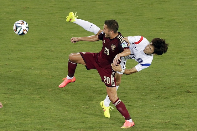 Russia's Viktor Fayzulin, left, and South Korea's Han Kook-young, right, challenge for the ball during their group H World Cup soccer match at the Arena Pantanal in Cuiaba, Brazil, Tuesday, June 17, 2014. (AP Photo/Thanassis Stavrakis)