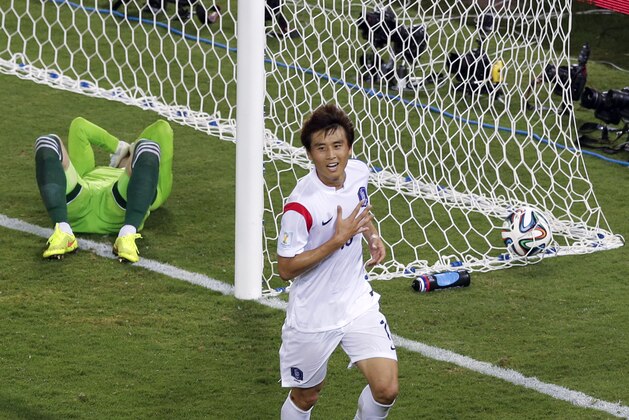Russia's goalkeeper Igor Akinfeev, left, lies in the goal as South Korea's Koo Ja-cheol celebrates after scoring the opening goal during their group H World Cup soccer match at the Arena Pantanal in Cuiaba, Brazil, Tuesday, June 17, 2014. (AP Photo/Thanassis Stavrakis)