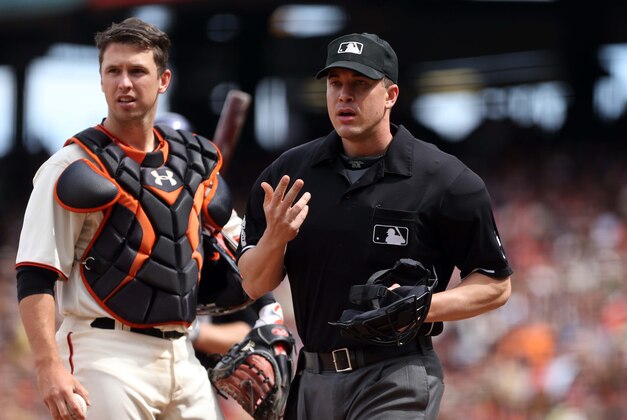 Jun 14, 2014; San Francisco, CA, USA; Home plate umpire Chris Segal (96) calls a San Francisco Giants trainer after being hit behind catcher Buster Posey (28) against the Colorado Rockies during the eighth inning at AT&T Park. Mandatory Credit: Kelley L Cox-USA TODAY Sports