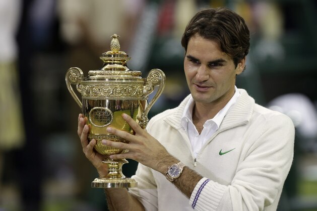 Roger Federer of Switzerland celebrates with the trophy after winning the men's singles final against Andy Murray of Britain at the All England Lawn Tennis Championships at Wimbledon, England, Sunday, July 8, 2012. (AP Photo/Anja Niedringhaus)
