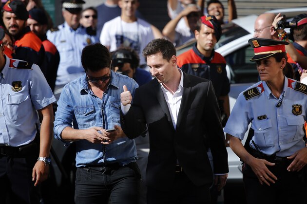 Barcelona F.C. soccer player Lionel Messi, centre right,  gestures, as he arrives at a court to answer questions in a tax fraud case,  in Gava, near Barcelona, Spain, Friday, Sept. 27, 2013. Barcelona star Lionel Messi and his father are appearing before a Spanish judge to answer questions in a tax fraud case. A complaint lodged by a Spanish state prosecutor in June said Messi and his father tried to conceal earnings from the player's image rights. The complaint alleged the Argentina international owed 4 million euros ($5.3 million) in back taxes from 2007, 2008 and 2009. (AP Photo/Emilio Morenatti)