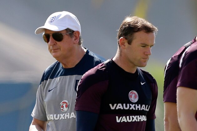England national soccer team coach Roy Hodgson, left, and Wayne Rooney walk away from each other after talking during a squad training session for the 2014 soccer World Cup at the Urca military base in Rio de Janeiro, Brazil, Monday, June 16, 2014.  (AP Photo/Matt Dunham)