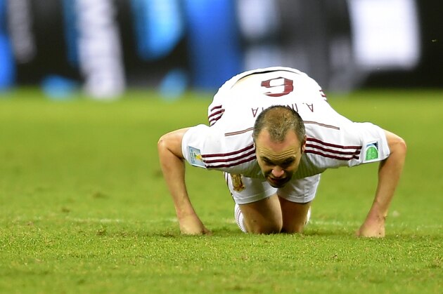 Spain's Andres Iniesta sinks to his knees during the group B World Cup soccer match between Spain and the Netherlands at the Arena Ponte Nova in Salvador, Brazil, Friday, June 13, 2014. (AP Photo/Manu Fernandez)
